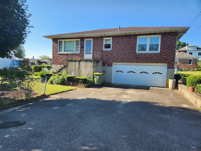 82 Hotchkiss St, Waterbury, CT 06704 - view of front of property featuring asphalt driveway, brick siding, and an attached garage