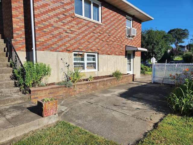 82 Hotchkiss St, Waterbury, CT 06704 - view of home's exterior featuring brick siding, stairway, stucco siding, cooling unit, and a patio area