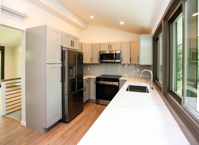 7 Hillcrest Ln, Weston, CT 06883 - kitchen with appliances with stainless steel finishes, an AC wall unit, tasteful backsplash, light wood-type flooring, and vaulted ceiling