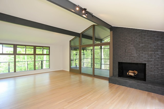 7 Hillcrest Ln, Weston, CT 06883 - unfurnished living room with a brick fireplace, vaulted ceiling, wood finished floors, and rail lighting