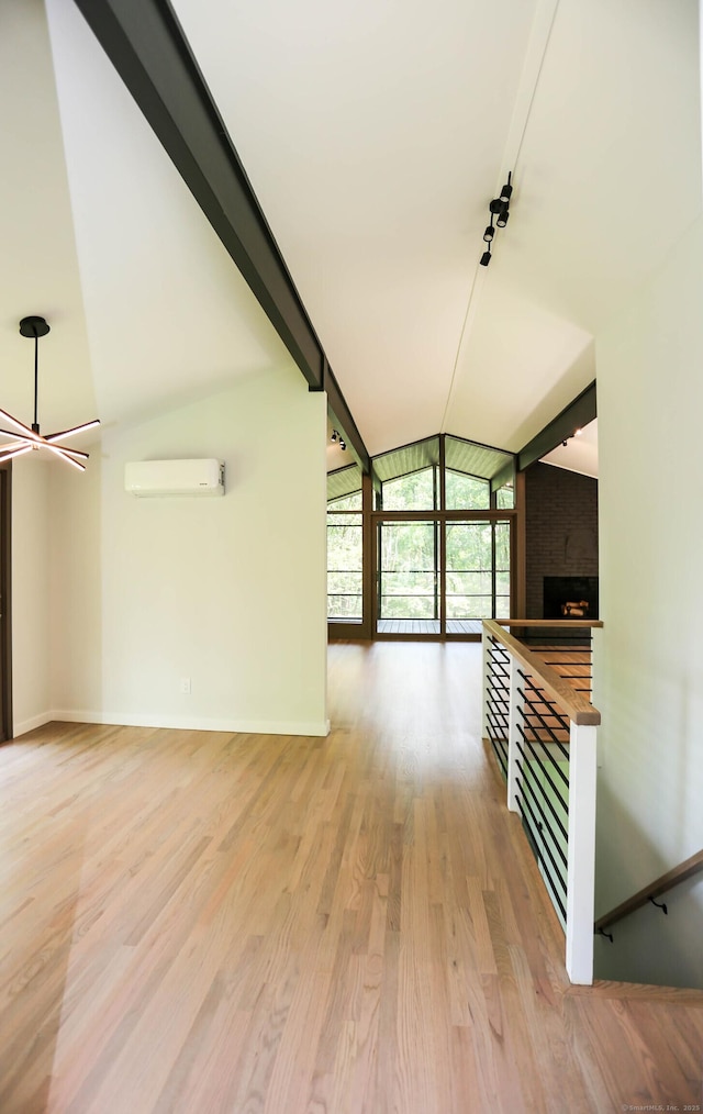 7 Hillcrest Ln, Weston, CT 06883 - unfurnished living room with a wall mounted air conditioner, wood finished floors, a large fireplace, and track lighting