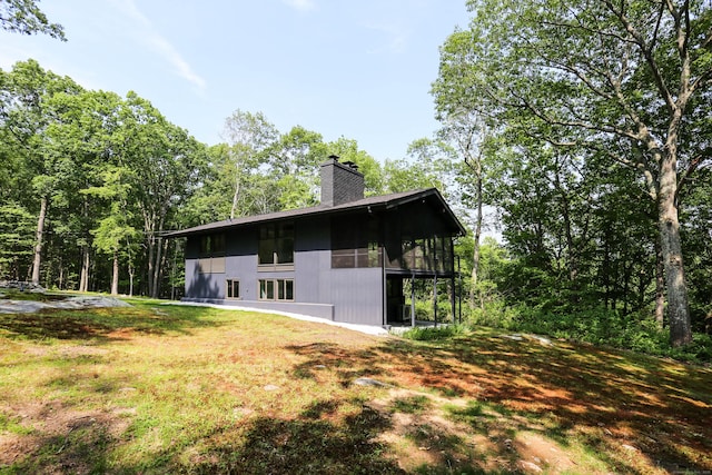 7 Hillcrest Ln, Weston, CT 06883 - view of home's exterior featuring a chimney, a sunroom, and a yard