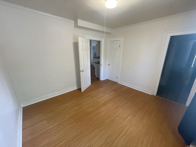 50 Beacon St, Waterbury, CT 06704 - unfurnished bedroom with light wood-style floors, ornamental molding, and a closet
