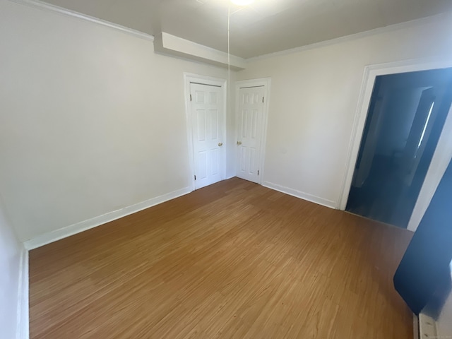 50 Beacon St, Waterbury, CT 06704 - unfurnished bedroom featuring wood finished floors, crown molding, and a closet