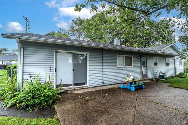 115 Sunburst Rd, Bridgeport, CT 06606 - rear view of property featuring a patio, a chimney, and a shingled roof