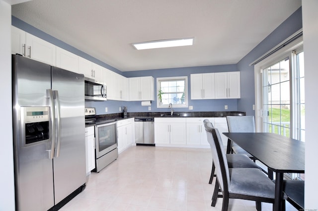 61 Windy Hill Ln Unit 61, Rocky Hill, CT 06067 - kitchen featuring stainless steel appliances, a sink, dark countertops, and white cabinetry