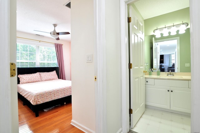 61 Windy Hill Ln Unit 61, Rocky Hill, CT 06067 - bedroom with a sink, connected bathroom, and light wood-style flooring