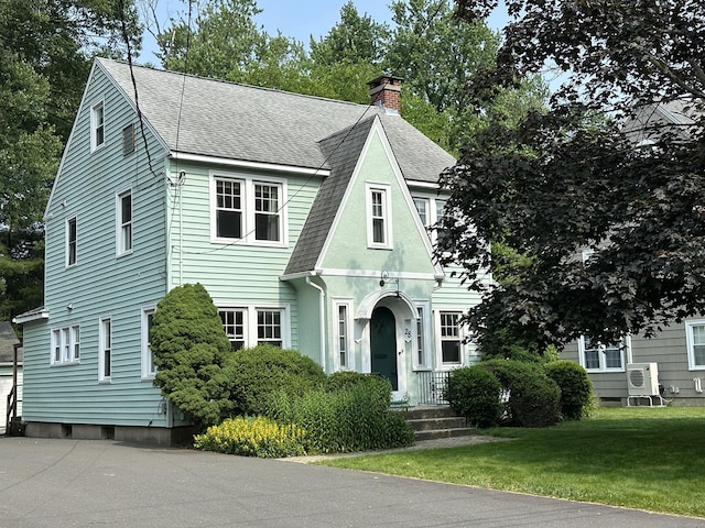 28 Wardwell Rd, West Hartford, CT 06107 - view of front of house featuring roof with shingles, a chimney, a front lawn, and a cooling unit