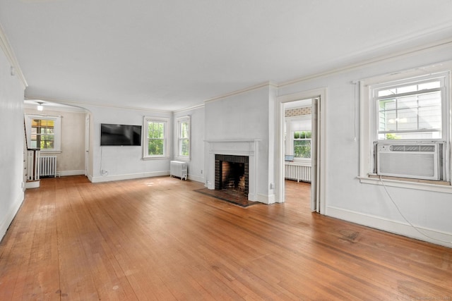 28 Wardwell Rd, West Hartford, CT 06107 - unfurnished living room featuring crown molding, radiator, light wood-type flooring, a fireplace, and healthy amount of natural light