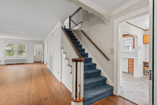 28 Wardwell Rd, West Hartford, CT 06107 - stairs featuring radiator heating unit, plenty of natural light, crown molding, hardwood / wood-style floors, and arched walkways