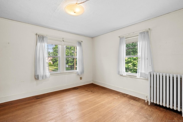 28 Wardwell Rd, West Hartford, CT 06107 - spare room featuring radiator heating unit, wood-type flooring, plenty of natural light, and baseboards