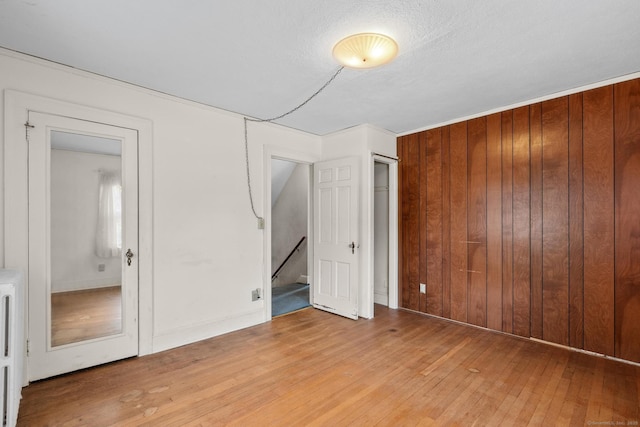 28 Wardwell Rd, West Hartford, CT 06107 - unfurnished bedroom with light wood-style floors, wooden walls, and a closet