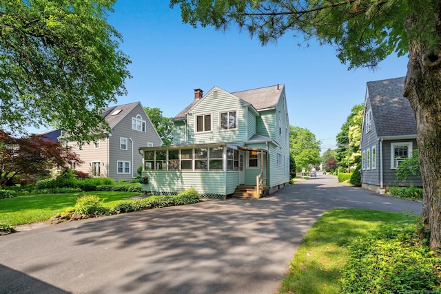 28 Wardwell Rd, West Hartford, CT 06107 - view of front of house with a sunroom, a chimney, a front lawn, and driveway