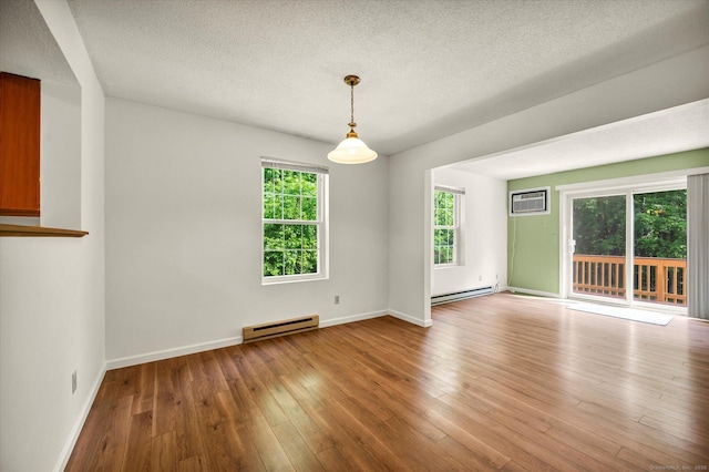 745 Merrow Rd Apt 157, Coventry, CT 06238 - unfurnished room featuring baseboard heating, a textured ceiling, hardwood / wood-style flooring, a wall mounted AC, and baseboards