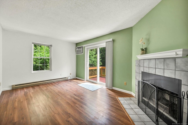 745 Merrow Rd Apt 157, Coventry, CT 06238 - unfurnished living room featuring a baseboard radiator, plenty of natural light, a textured ceiling, wood finished floors, and a wall mounted AC