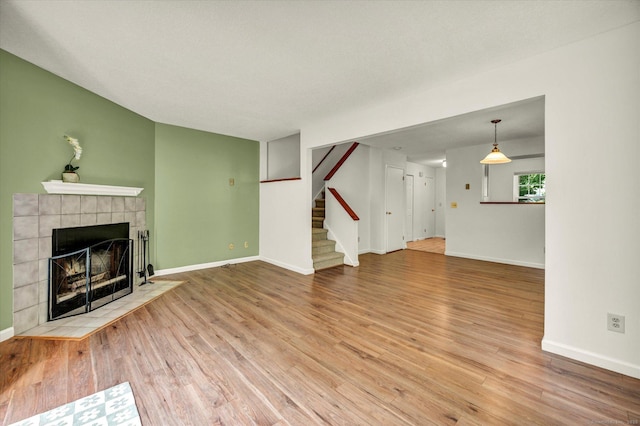 745 Merrow Rd Apt 157, Coventry, CT 06238 - unfurnished living room with a tile fireplace, wood finished floors, stairway, and baseboards