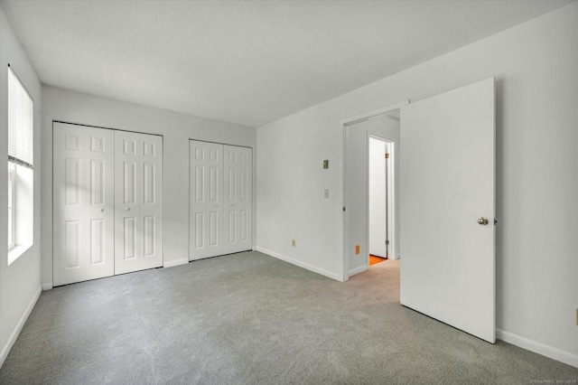 745 Merrow Rd Apt 157, Coventry, CT 06238 - unfurnished bedroom featuring multiple closets, carpet flooring, baseboards, and a textured ceiling