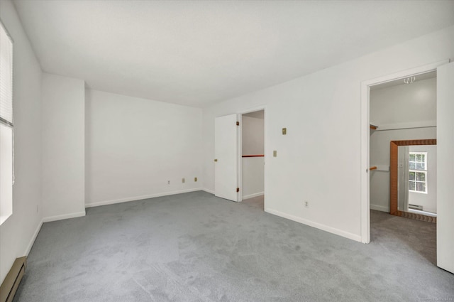 745 Merrow Rd Apt 157, Coventry, CT 06238 - unfurnished bedroom featuring a walk in closet, carpet, baseboards, and a baseboard heating unit
