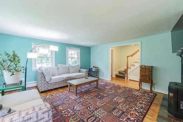 52 N Grand St, Suffield, CT 06093 - living area with a wood stove, stairway, baseboard heating, a baseboard radiator, and wood finished floors