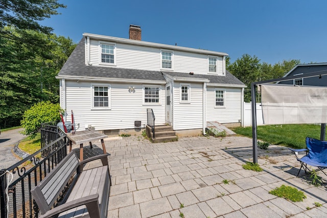 52 N Grand St, Suffield, CT 06093 - rear view of house with a patio, a chimney, and roof with shingles