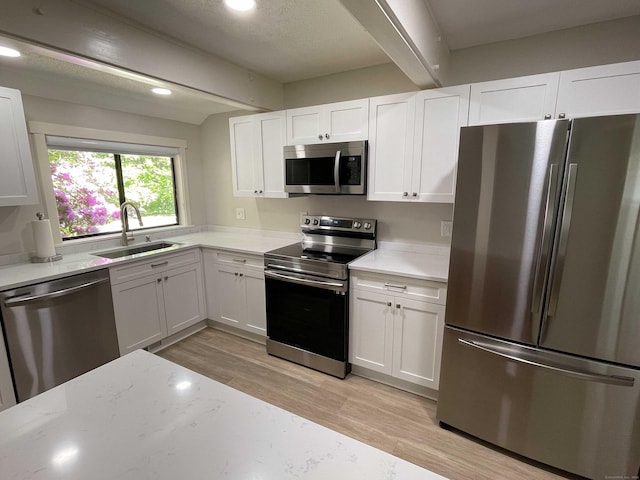 8 Highpoint Ct Unit 8, Woodbury, CT 06798 - kitchen featuring appliances with stainless steel finishes, a sink, beam ceiling, light wood-type flooring, and white cabinetry
