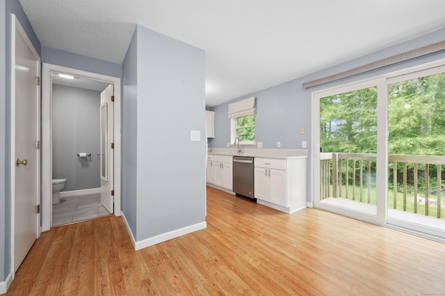 30 Seymour Rd Apt D3, Plymouth, CT 06786 - kitchen with stainless steel dishwasher, light countertops, white cabinetry, and light wood finished floors