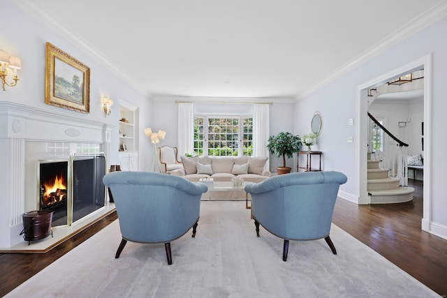 66 Stanton Rd, Darien, CT 06820 - living room featuring wood finished floors, ornamental molding, a fireplace, built in shelves, and stairway