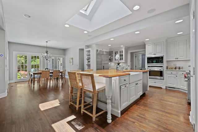 66 Stanton Rd, Darien, CT 06820 - kitchen with built in appliances, white cabinets, a chandelier, recessed lighting, and a center island