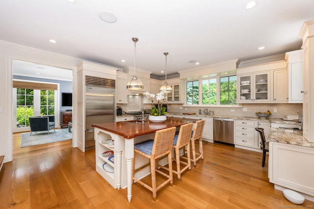 3 Bittersweet Trl, Norwalk, CT 06853 - kitchen featuring appliances with stainless steel finishes, a kitchen island with sink, backsplash, a breakfast bar, and pendant lighting