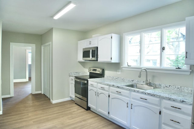 10 Fleming St, Waterbury, CT 06710 - kitchen featuring stainless steel appliances, a sink, white cabinetry, light wood finished floors, and baseboards