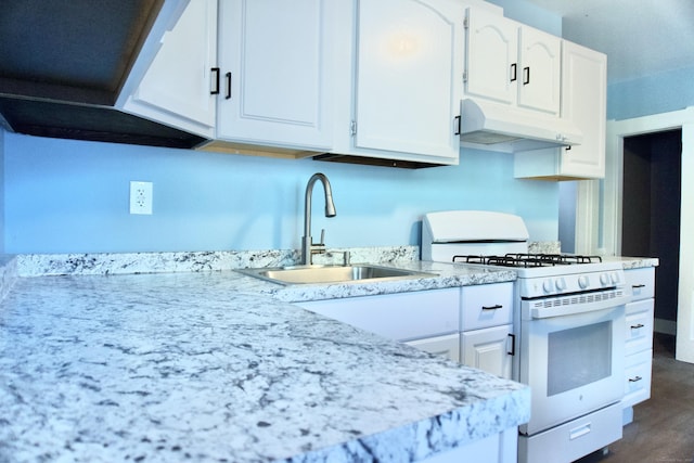 10 Fleming St, Waterbury, CT 06710 - kitchen featuring white gas stove, under cabinet range hood, a sink, white cabinetry, and light countertops