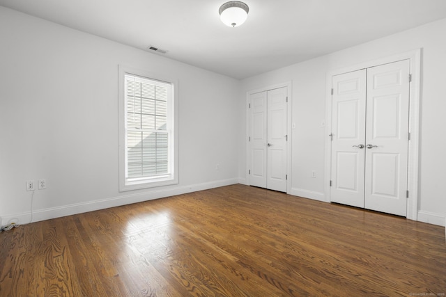 1-1/2 Colony St, Norwalk, CT 06851 - unfurnished bedroom with multiple closets, wood finished floors, and baseboards