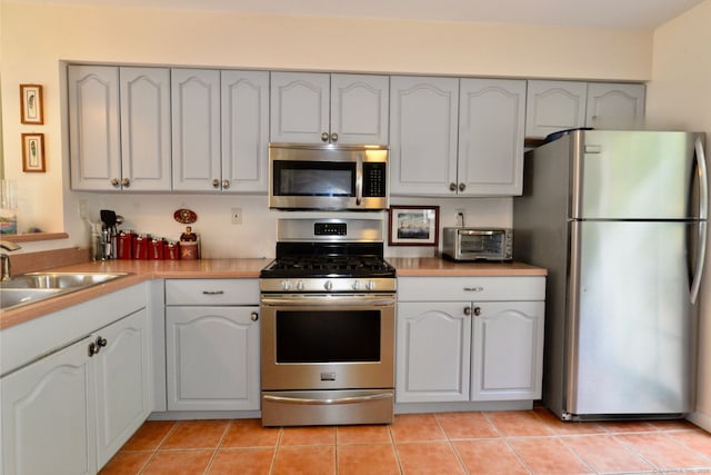 27 Indian Hill Rd Unit 27, Monroe, CT 06468 - kitchen with stainless steel appliances, a sink, light countertops, and light tile patterned flooring