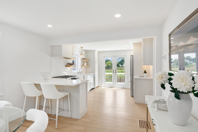 105 Blake Dr, Fairfield, CT 06824 - kitchen featuring stainless steel appliances, light wood-style flooring, light countertops, tasteful backsplash, and recessed lighting
