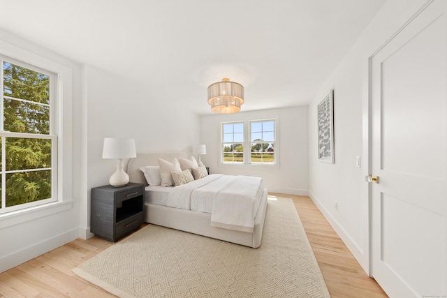 105 Blake Dr, Fairfield, CT 06824 - bedroom with light wood finished floors, baseboards, and a chandelier