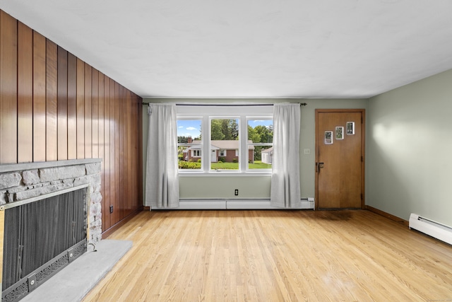 26 Caroldon Rd, Middletown, CT 06457 - unfurnished living room featuring wood finished floors, wooden walls, a stone fireplace, and baseboard heating