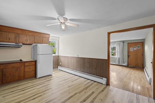 26 Caroldon Rd, Middletown, CT 06457 - kitchen with freestanding refrigerator, a baseboard radiator, under cabinet range hood, light wood-style floors, and brown cabinetry
