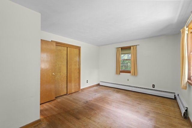 26 Caroldon Rd, Middletown, CT 06457 - unfurnished bedroom featuring a baseboard heating unit, wood finished floors, and a closet