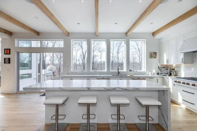 4 Vona Way, Newtown, CT 06470 - kitchen featuring white gas stovetop, a breakfast bar area, healthy amount of natural light, white cabinets, and beam ceiling