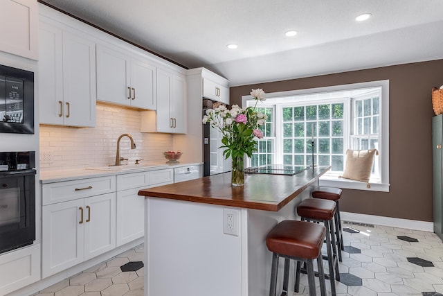 59 Davids Hill Rd, Woodbury, CT 06798 - kitchen featuring black appliances, decorative backsplash, light tile patterned floors, a kitchen bar, and white cabinets