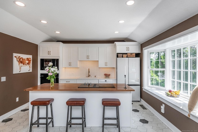 59 Davids Hill Rd, Woodbury, CT 06798 - kitchen with black appliances, lofted ceiling, butcher block counters, white cabinets, and a breakfast bar
