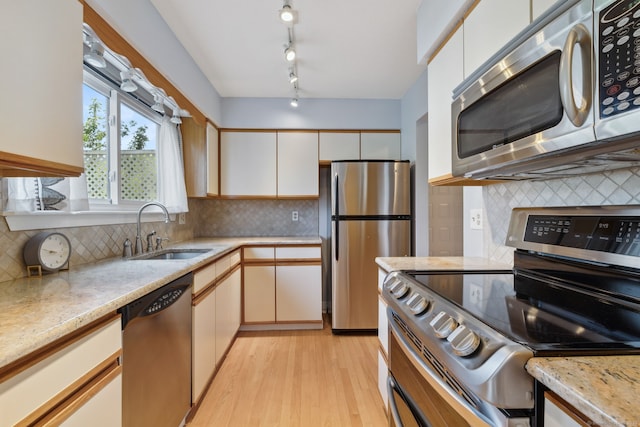 66 Staffordshire Commons Dr Unit 66, Wallingford, CT 06492 - kitchen featuring appliances with stainless steel finishes, a sink, tasteful backsplash, and light wood-style flooring
