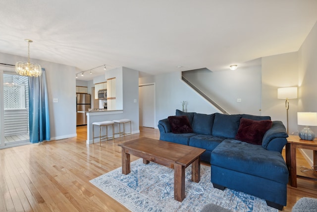 66 Staffordshire Commons Dr Unit 66, Wallingford, CT 06492 - living area featuring light wood-style floors, a chandelier, baseboards, and stairs