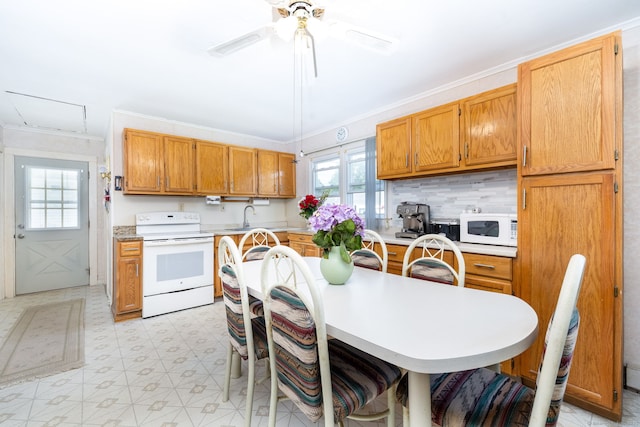 kitchen with white appliances, plenty of natural light, light countertops, and crown molding