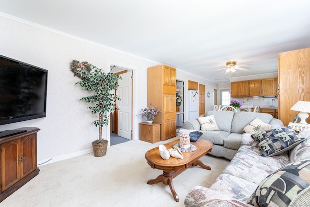 living area featuring carpet floors, crown molding, and ceiling fan