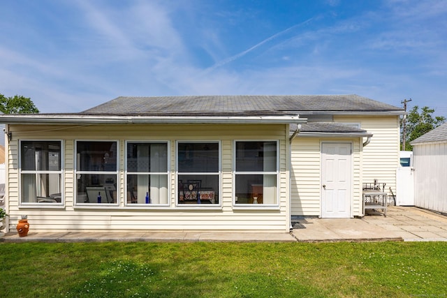 back of house with a patio area and a yard