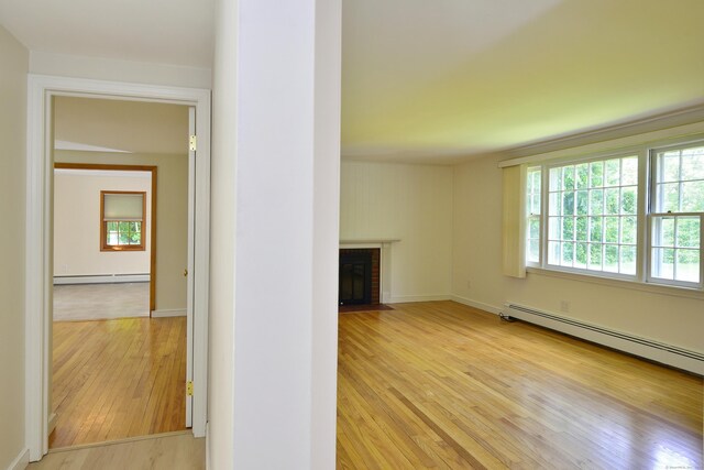 118 Putnam Rd, Pomfret, CT 06259 - unfurnished living room with baseboard heating, light wood finished floors, a fireplace, and baseboards