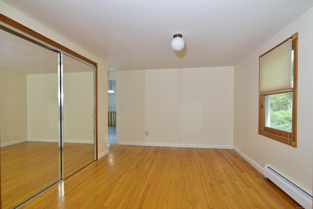 118 Putnam Rd, Pomfret, CT 06259 - unfurnished bedroom featuring a baseboard heating unit, light wood finished floors, a closet, and baseboards