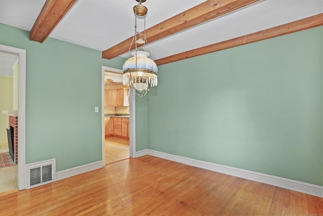 2 Stowe Pl, Trumbull, CT 06611 - empty room featuring beam ceiling, light wood-style floors, a chandelier, and a brick fireplace