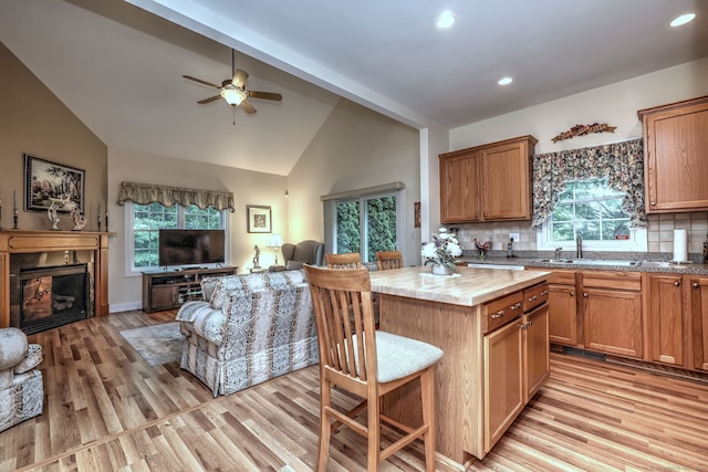123 Meadow Brook Rd Unit 123, Oxford, CT 06478 - kitchen featuring open floor plan, light wood finished floors, decorative backsplash, a ceiling fan, and a fireplace